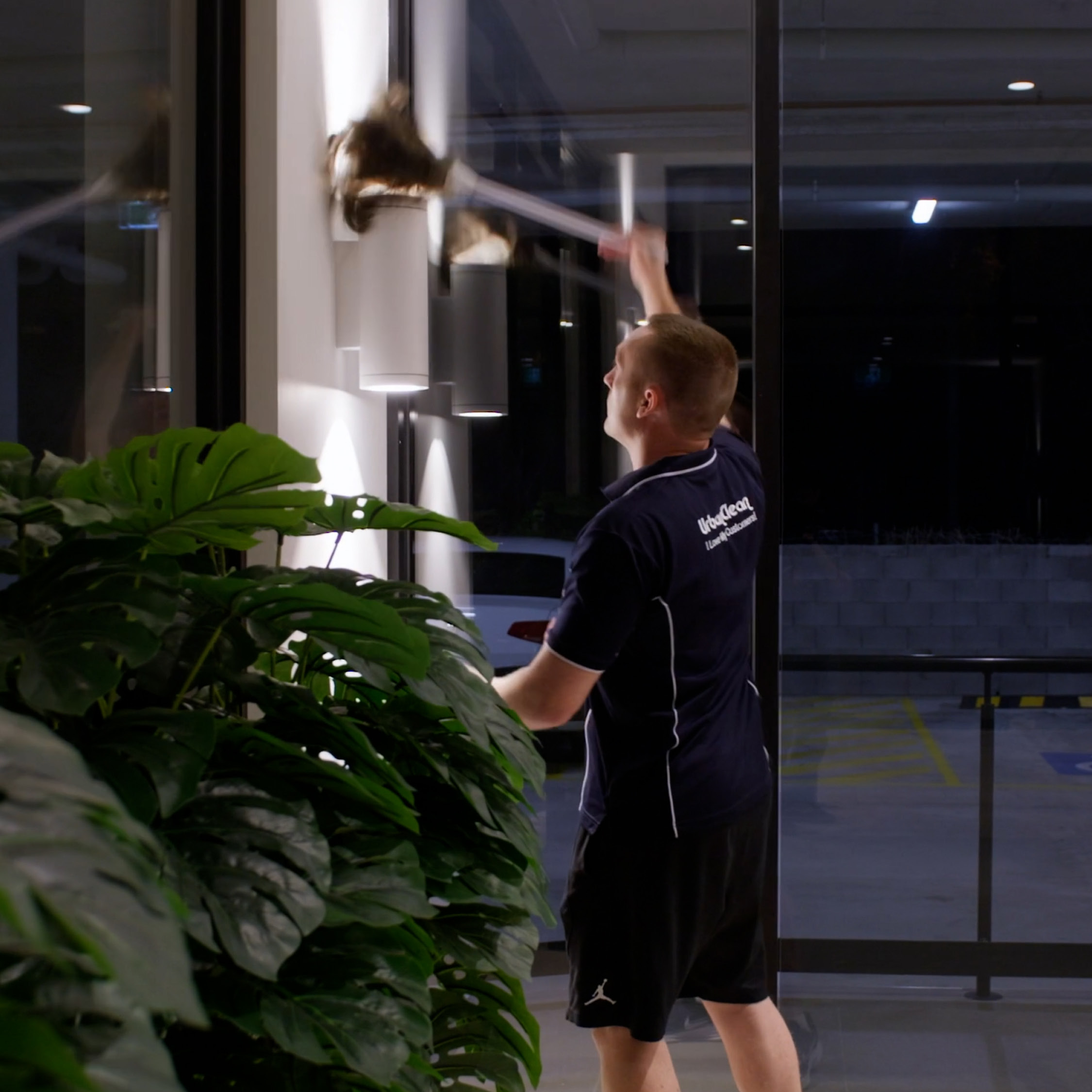 Cleaner working on a building entrance after hours.